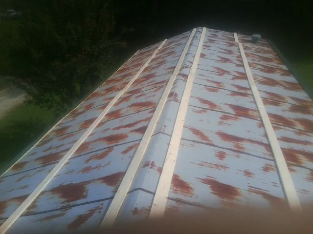 Rusted metal roof panels with new wood purlins before replacement — Storm Damage Roof Repair in Braselton by Roofing Brothers