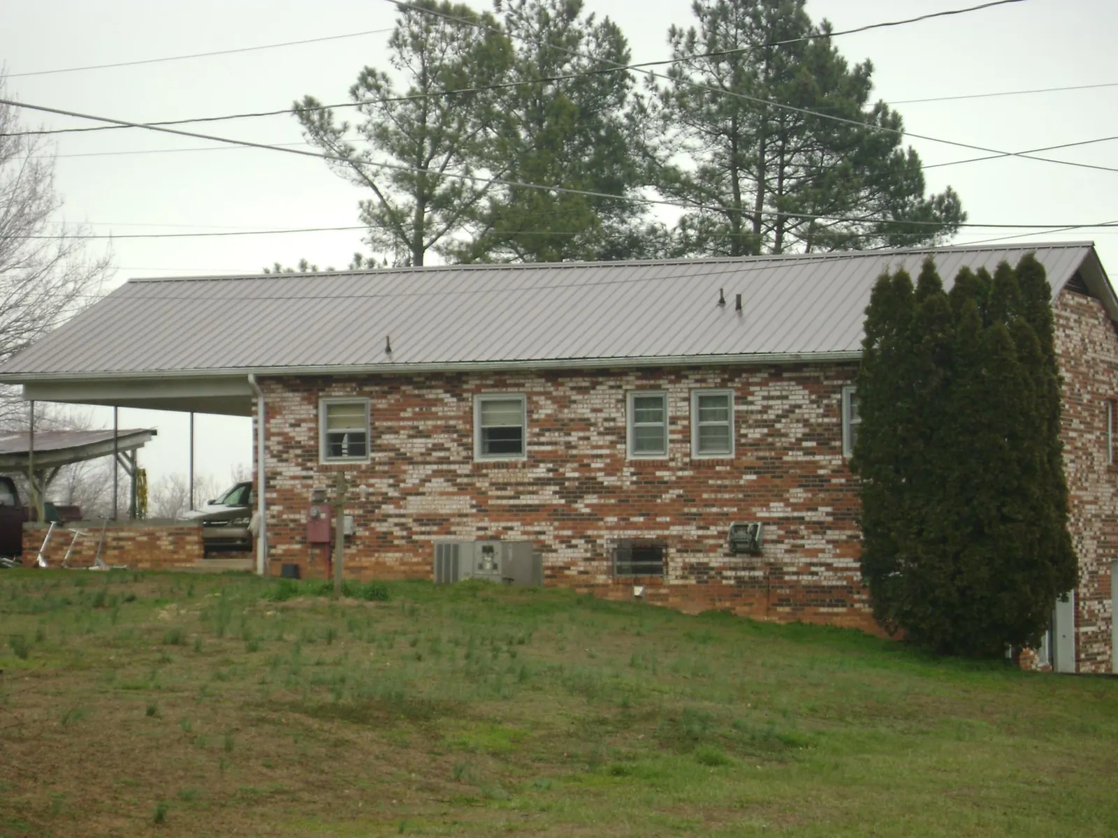 Gray metal roof on a brick split level home with a carport in Braselton