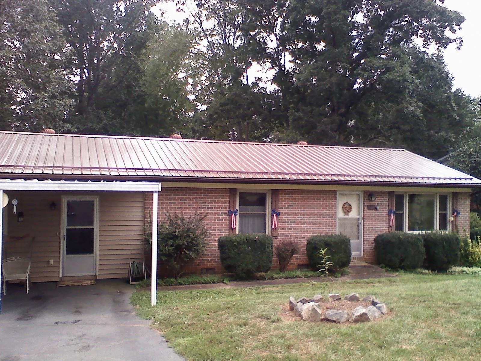 Bronze metal roof and carport on a brick ranch home — Roof Repair work by our crew in Braselton